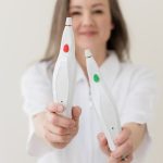 Practitioner holding two Plexr handheld devices used for semi-ablative plasma skin treatments in Calgary clinic