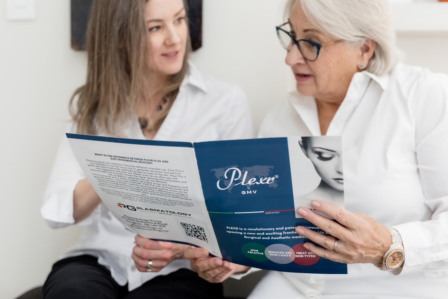 Two women reviewing a Plexr brochure together during an educational consultation in a medical plasma aesthetics clinic