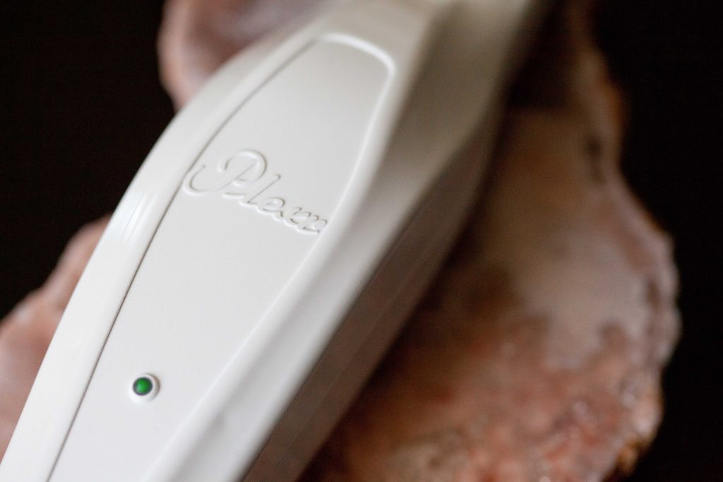 Close-up of the Plexr plasma medical aesthetics device used for non-surgical skin treatments