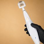 Plexr Lumen plasma energy microneedling device held in a gloved hand