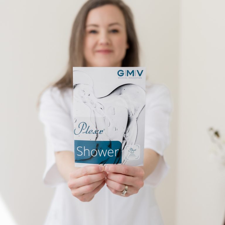 Woman holding a Plexr Shower treatment brochure in a medical aesthetics clinic